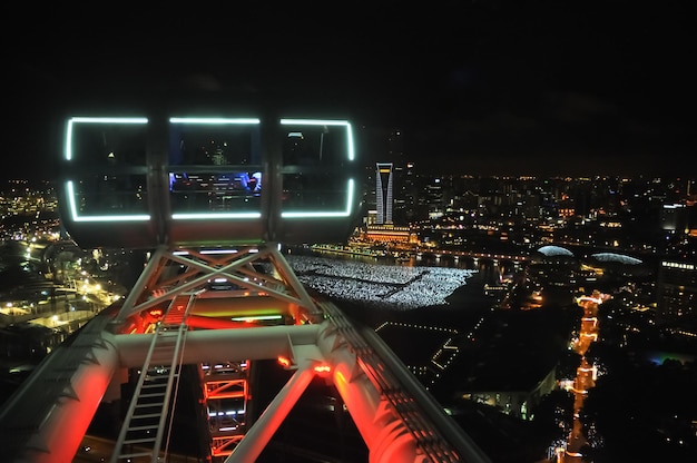 にぎやかな街の巨大なフライヤーホイールのキャビンからの夜景