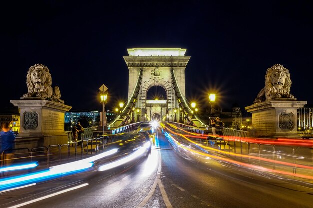 Night scene of illuminated Chain Bridge which spans Danube river Budapest Hungary Red and white c