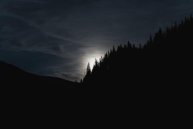 Night scene in the tatras the moon rises from behind the mountains illuminating the silhouettes