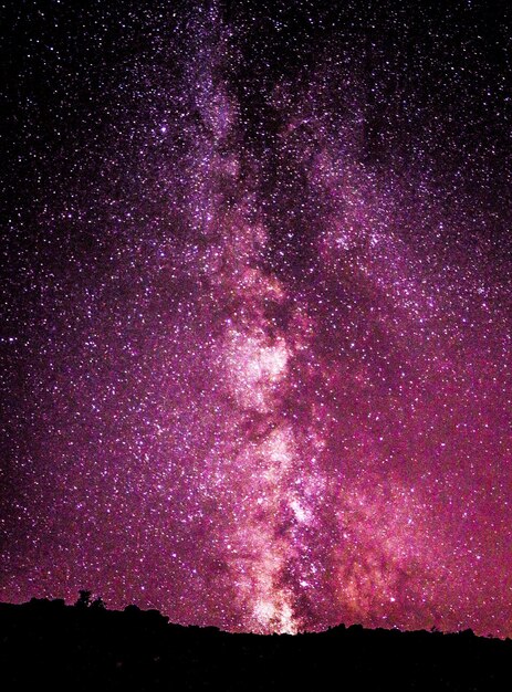 Photo a night sky with a large star cluster in the foreground