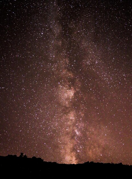 Photo a night sky with a large star cluster in the foreground