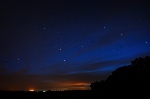 Night sky with stars. Bright sunset with clouds.