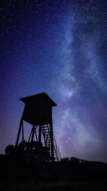 Photo a night sky with a tower and the milky way in the background