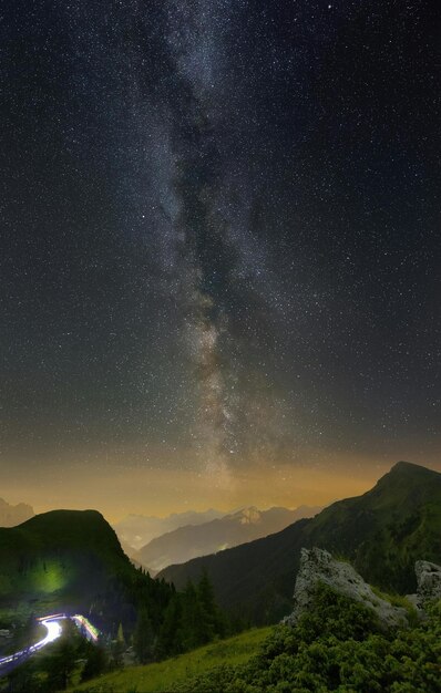 a night sky with a view of the mountains and the stars