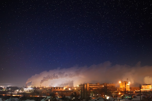 Night starry sky over an industrial area of the city