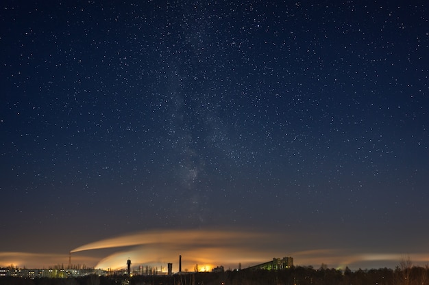 도시의 산업 지역 위에 은하수가 있는 밤하늘. 러시아에서 겨울에 촬영 된 풍경입니다.