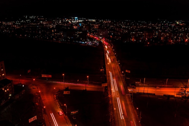 Ночные улицы, шоссе и автомобильное движение в городе Ивано-Франковск, огни от автомобильного движения, вид сверху