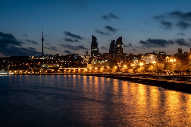 Night view of Baku with the Flame Towers skyscrapers, television tower and the seaside of the Caspian sea