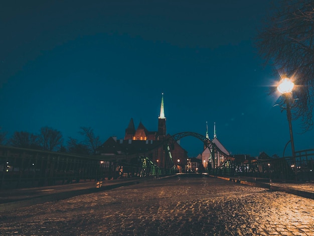 Night view on cobblestone bridge way to the old city district