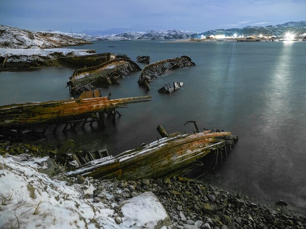 Night view of graveyard of ships, old fishing village, Teriberka, Russia