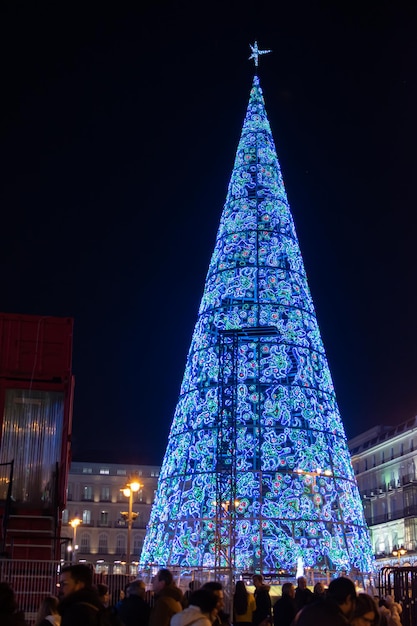 クリスマスにマドリードのプエルタデルソルの照らされたクリスマスツリーの夜景