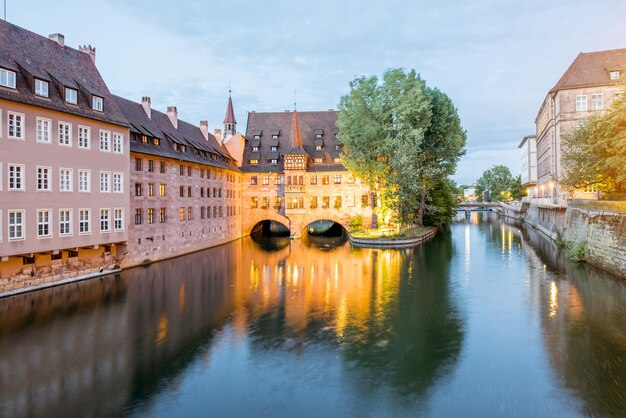 ドイツ、ニュルンベルク市の美しい照明付きの建物のある水路の夜景