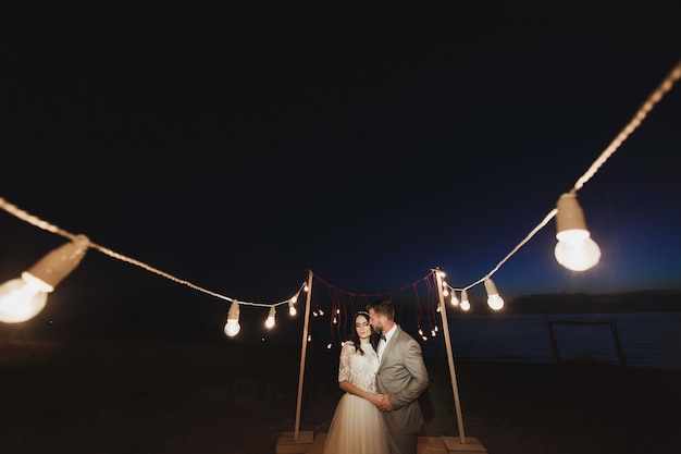 Photo night wedding ceremony. the bride and groom hugging.