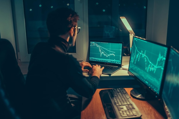 Photo nighttime analysis guy typing on laptop at home office