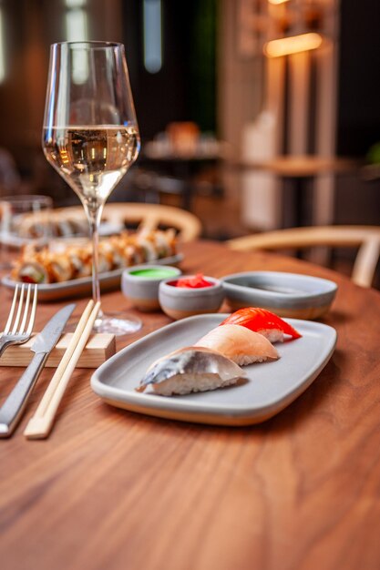 Nigiri set mackerel sea bass salmon on a plate on a table in a sushi bar