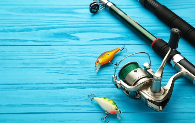 Nikolaev Ukraine 08 july 2022 Fishing rods and spinnings in the composition with accessories for fishing on blue background