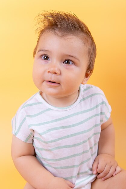 Nine months baby on yolk background emotions beautiful child