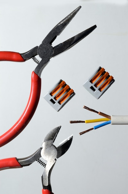 Nippers, wire and terminal blocks on a light background. close-up top view.