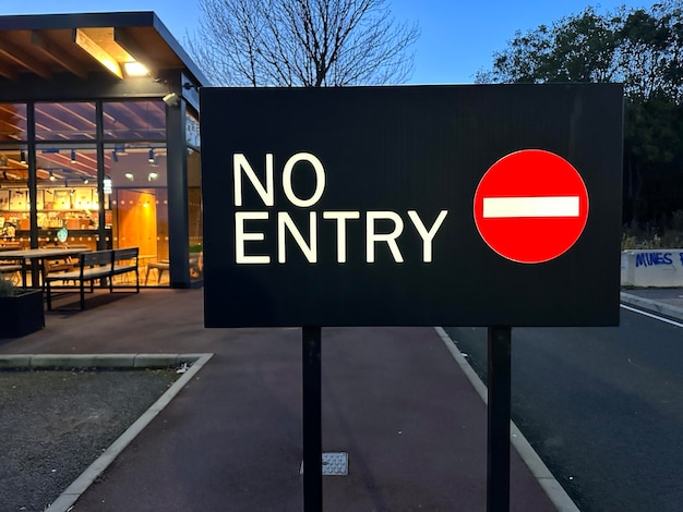 Foto nessun cartello di arresto d'ingresso luminoso di fronte al caffè con luci serali