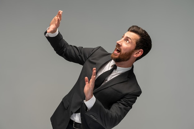 No it39s scary Profile portrait of frightened shocked businessman in suit raising hands in fear looking horrified and panicking hiding from phobia Indoor studio shot isolated on grey background