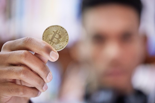 Photo no middleman, no problem. shot of an unrecognisable man holding a bitcoin.