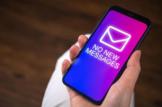携帯電話の画面に新しいメッセージのテキストはありませんクローズアップコミュニケーションのコンセプト写真をチャットするためにスマートフォンを使用している女性