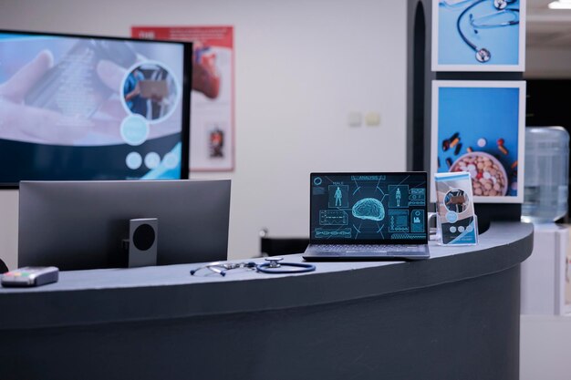 No one consulting results of brain scans displayed on laptop computer screen on neuroscience hospital reception desk. Lobby of empty clinic with no patients inquiring about health status.