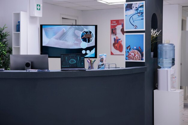 Photo no one working in empty medical clinic patient care area. nobody scheduling appointments with medical specialist in hospital. brain scans on computer without being studied by neurologist.