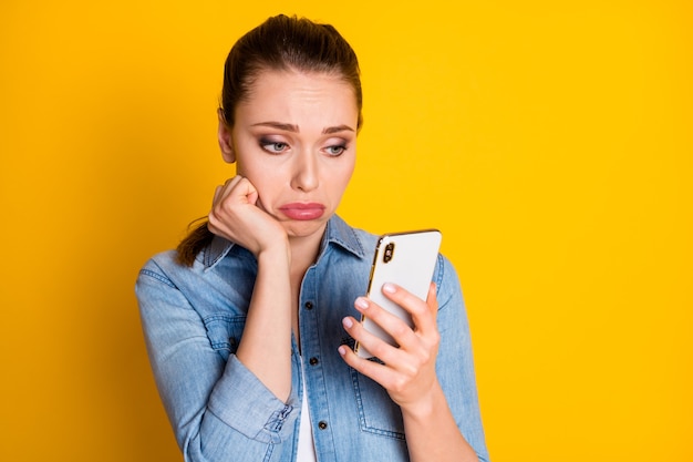 No one writes me. Frustrated cry girl use cellphone wait for her boyfriend texting typing sms comment feedback wear good look clothes isolated bright shine color background