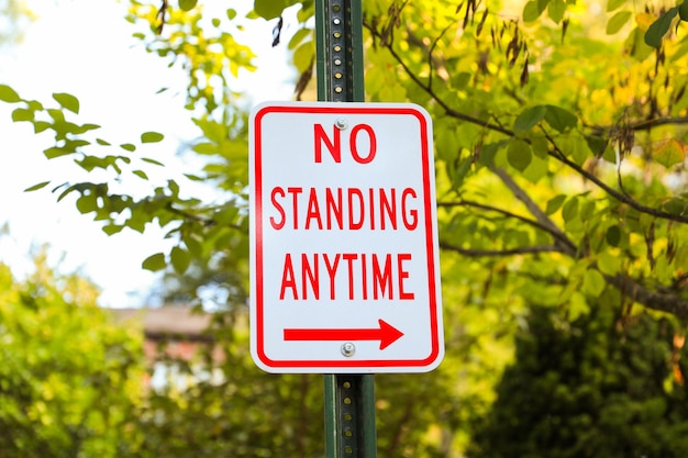 No Parking sign rusted and aged against a blurred urban background conveying urban