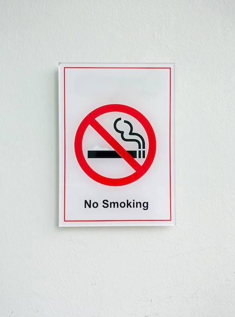 No smoke sign from the plastic sheet on the white wall in the office building.