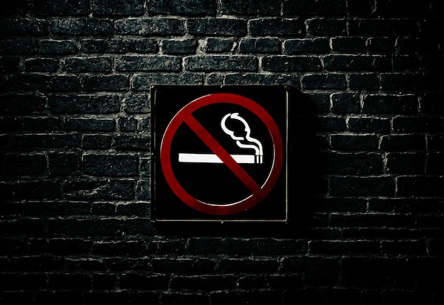 어두운 벽돌 벽 에 담배 를 피우지 말라는 표지판