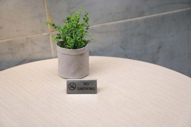 Photo no smoking sign on light wooden table 