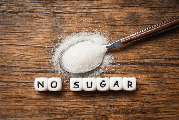 Фото Нет блоков текста сахара с белым сахаром на деревянной ложке - предлагая сидеть на диете и есть меньше сахара для концепции здоровья