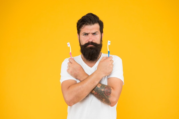 No toothache bearded man hold toothbrushes hipster with tooth\
brushes teeth care oral hygiene dental care fresh breath protecting\
teeth take care of your teeth