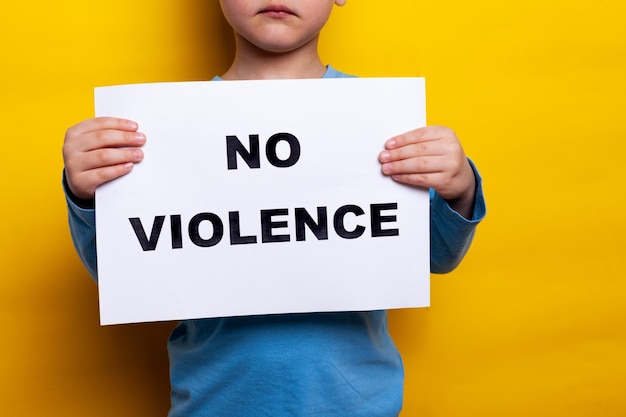 暴力はありません子供は顔のない碑文のある一枚の紙を持っています