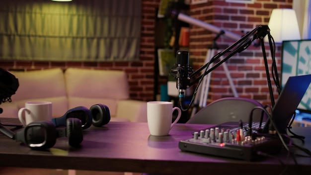 Nobody in podcast home studio with microphone boom arm and audio recording professional mixer on desk. Empty internet online radio setup for producing podcasts for social media.