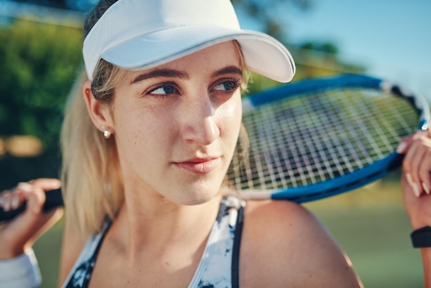 nobody who ever gave it their best regretted it shot of a sporty young woman standing on a tennis court with a tennis racket