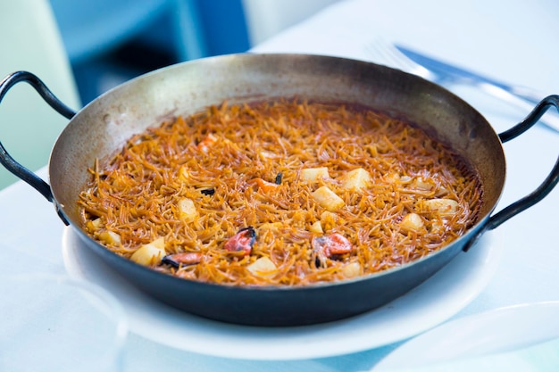 Noedelpaella met zeevruchten. Traditioneel Spaans recept voor Fideua.