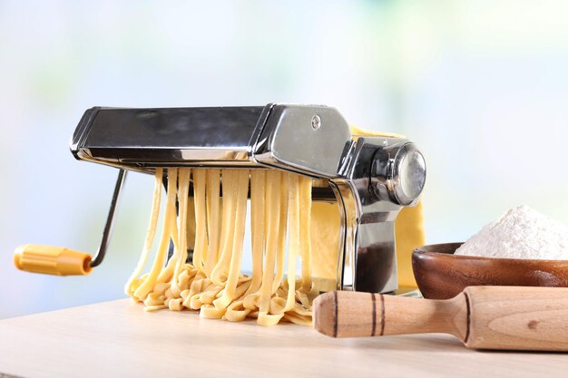 Noedels maken met een pasta machine op een lichte achtergrond