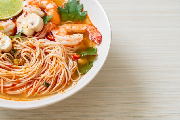 noedels met pittige soep en garnalen in witte kom (Tom Yum Kung) - Asian food style