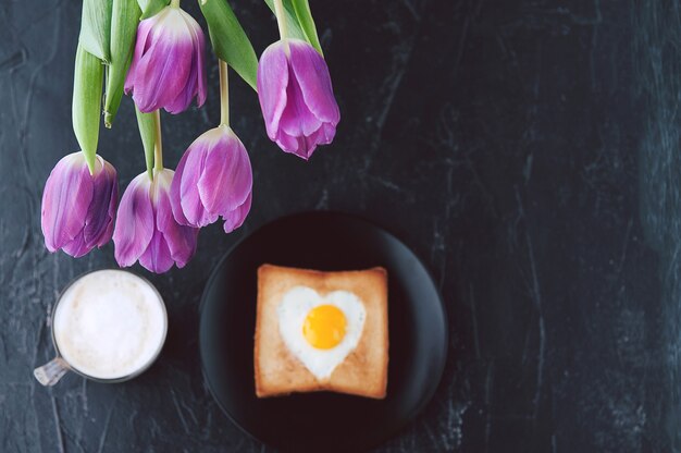 Nog steeds ontbijt voor een geliefde met tulpen op een donkere achtergrond