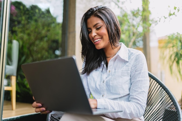 Nomade op het werk Zelfverzekerde jonge Latijnse vrouw die videogesprek voert op laptop