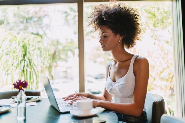 Nomade op het werk Zelfverzekerde jonge Latijnse vrouw die videogesprek voert op laptop