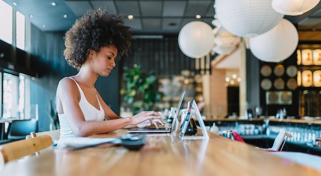 Nomade op het werk Zelfverzekerde jonge Latijnse vrouw die videogesprek voert op laptop