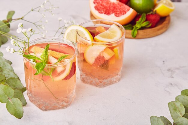 Non alcoholic refreshing tonic with citrus fruits Two drinking glasess Summer detox cold cocktails