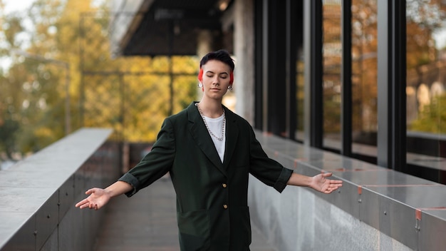 Photo non binary person with modern hairstyle posing outside