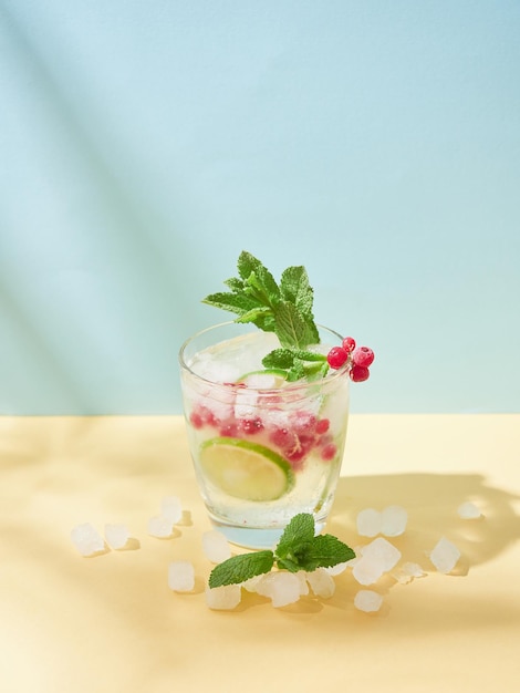 Nonalcoholic soda water tonic Cold drink in crystal glass with ice lime slice redcurrant and min