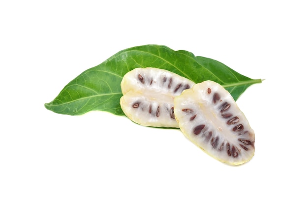 Плоды нони или Morinda Citrifolia с нарезанными и зелеными листьями, изолированные на белом фоне.