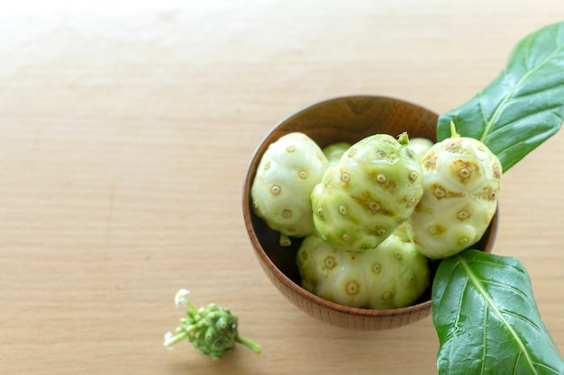 Noni or Morinda citrifolia, great morinda, Indian mulberry, beach mulberry, or cheese fruit on wood table